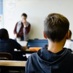 Jongere zit in de klas en krijgt onderwijs