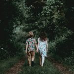 twee kinderen lopen door het bos