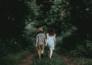 twee kinderen lopen door het bos