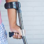 a person holding a crutch and walking cane